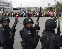 Penduduk Urumqi (ibukota Xinjiang) dikepung pasukan keamanan bersenjata Cina (AP Photo/Ng Han Guan)