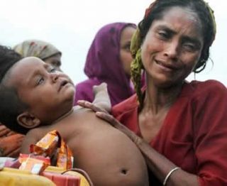 Seorang wanita muslim Rohingya Myanmar berada dalam sebuah perahu bersama bayinya dalam pelariannya ke Bangladesh