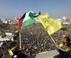 Warga Palestina mengibarkan bendera Palestina dan bendera Fatah ketika perayaan milad Fatah ke-48 di kota Gaza, 4 Januari 2013. (REUTERS/Mohammed Salem)