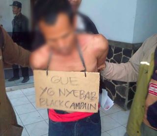 Salah seorang pelaku penyebaran kampanye hitam yang menyerang pasangan Ru'yat-Aim pada Pilkada Kota Bogor, diamankan oleh petugas, (11/9/2013). (ist)