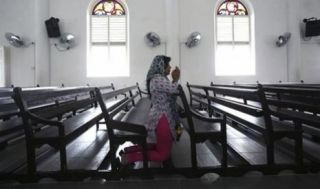 Seorang wanita tengah berdoa di Gereja Our Lady of Lourdes di Klang, luar Kuala Lumpur  (Foto: republika)