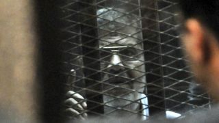 Dr. Muhammad Mursi dibalik jeruji terdakwa di dalam pengadilan (foto: bbcarabic.com)