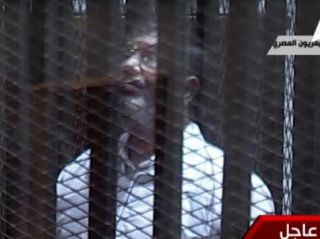 Presiden Mursi dalam sidang pengadilan. (aljazeera.net)