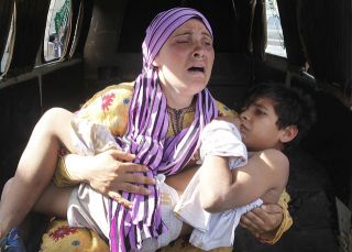 Seorang ibu warga Suriah menggendong anaknya yang jadi korban penembakan di dekat perbatasan Suriah-Lebanon - Foto: Republika.co.id