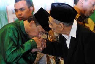 Ketua Partai Persatuan Pembangunan Suryadharma Ali (kiri) mencium tangan Ketua Majelis Syariah KH Maimun Zubair (kanan) usai melakukan konferensi pers di Kantor DPP PPP, Jakarta, Selasa (22/4/2014). - (Foto: tribunenews.com)