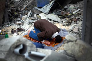 Ilustrasi - Seorang pria Palestina sedang sujud dalam shalatnya di antara puing-puing rumahnya yang hancur akibat dibom oleh aksi militer Israel terhadap Hamas pada tahun 2009, di Bait Lahiya. (Reuters / tageswoche.ch)