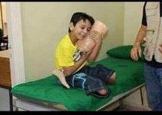 Anak Palestina sedang memeluk kaki palsu yang baru diterimanya.  (@AliSiamPress)