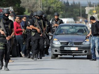 Anggota polisi yang berjaga-jaga di bawah rumah tempat pelaku terorisme bertahan (aljazeera.net)