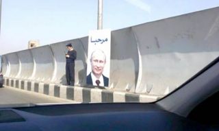 Polisi Mesir yang menjaga poster presiden Rusia, Vladmir Putin di hari kunjungannya ke Kairo. (Islammemo.cc)