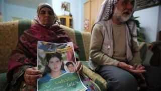 Ibu dari Malak al-Khatib membawa foto putrinya yang ditawan di penjara Israel. (islammemo.cc)