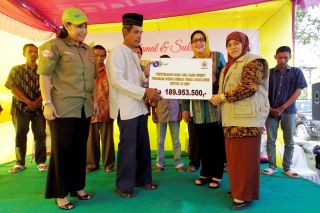 Istri Gubernur Sumatera Utara, Sutias Handayani sedang menyerahkab bantuan rehabilitasi rumah tidak layak huni, di Kecamatan Percut Sei Tuan, Kabupaten Deli Serdang, Jumat Sore (13/2) (IST)