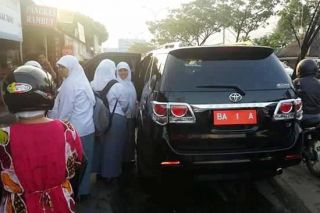 Mobil dinas Walikota Padang tertangkap kamera sedang menangkut pelajar yang tidak dapat angkot, Kamis (26/2) (IST)