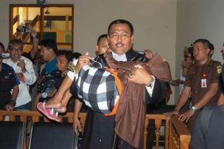 Pengacaran Nenek Asyani, Supriono langsung menggendong terdakwa usai sidang penangguhan penahanan di PN Situbondo. Senin (16/3/15).  (tribunnews.com)