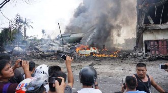 Kepulan asap masih terlihat dari puing-puing pesawat TNI berjrenis Hercules yang jatuh di Medan. (Detik.com)
