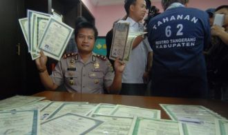 Kapolsek Pd Aren Kompol Hafidz Herlambang menunjukan barang bukti sejumlah ijazah palsu dan juga seorang pelaku Santoso alias Santosa saat gelar perkara di Mapolsek pd Aren, Tangerang Selatan, Selasa (26/3). (antara/rol)