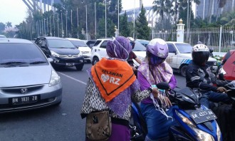 Relawan RZ bagikan 1500 masker pada pengguna jalan di Simpang lampu merah Kantor Gubernur, Kota Pekanbaru, Senin (3/8/15).  (Rena/RZ)