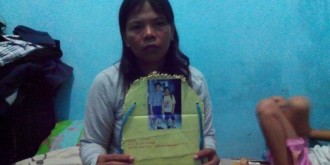 Ibu Evan Christoper, Ratna Dumiarti, memegang papan nama yang dibawa anaknya saat MOS di SMP Flora, Bekasi Utara. (kompas.com)