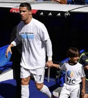 Ronaldo menggandeng bocah pengungsi Suriah. (bola.net)