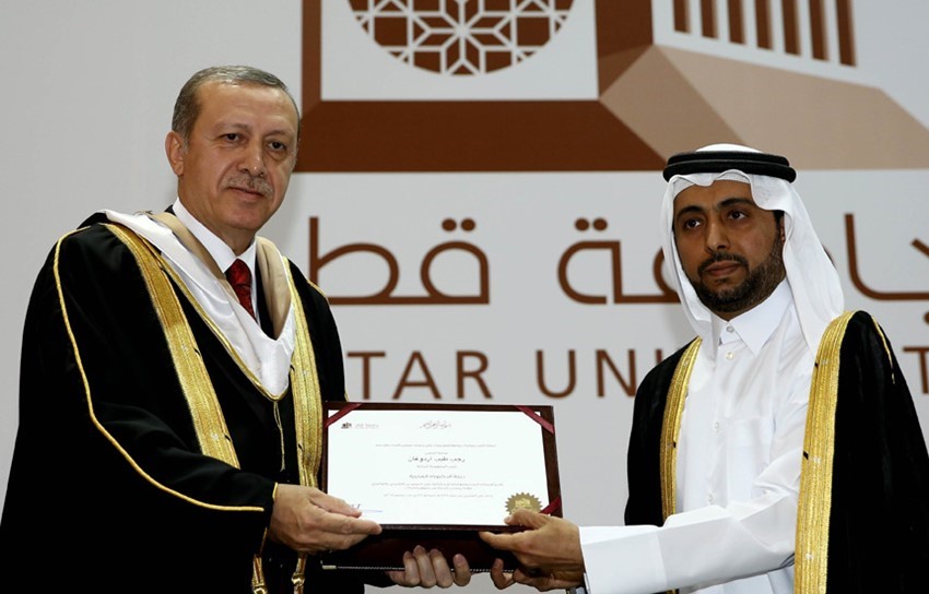 Presiden Qatar University, Dr. Hassan Rashid Al-Derham dan Presiden Turki, Recep Tayip Erdogan dalam seragam khas wisudawan di Hall Ibnu Khaldun, Universitas Qatar, Doha, Qatar (Sumber Foto: Kantor Kepresidenan Turki)
