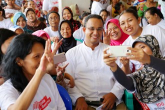 Anies Baswedan tampak sedang berfoto dengan warga penghuni Rusunawa Pesakih. (IST)