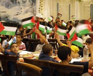 Ilustrasi - Anak-anak yatim mengibarkan bendera Palestina ketika ifthar Ramadhan yang diselenggarakan oleh Hamas di Damaskus, 31 Agustus 2010 (Getty Images)